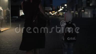 荷兰鹿特丹，夜空步行街上带儿子的妇女的慢镜头